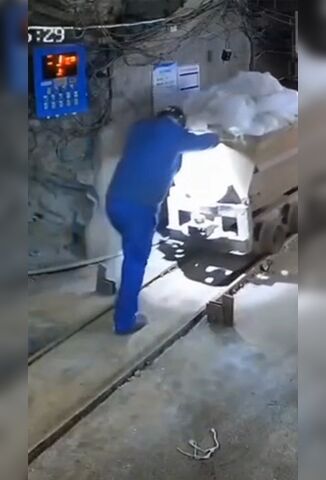 Worker Pushing A Mine Truck Goes Down With His Spoils