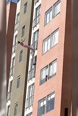 Woman In Pink Backflips Of Apartment Building