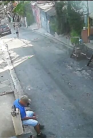 Man In Blue Casually Sitting On The Sidewalk's About To Have A Real Bad Day