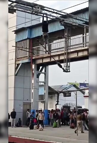Indian Man Hangs From Gantry At The Station Fries Himself On Overhead Power Lines