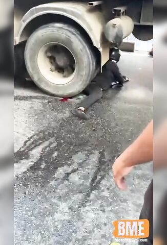 Biker In Black Pinned Under The Wheels Of A Truck