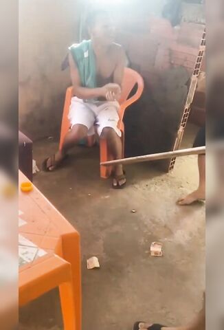 Man In A Plastic Chair Suffers Beating By Lumps Of Wood