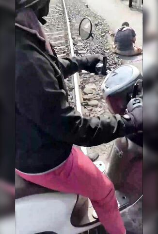 Man Missing An Arm Sitting By The Side Of The Railroad Track