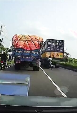 Speeding Bikers Try To Navigate Between Two Trucks