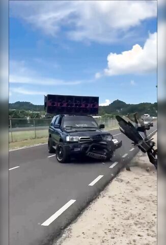 Boom Boxing Car Pulls Across Biker