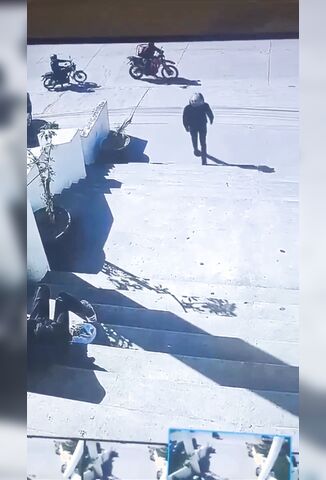 Two Men Sitting On The Steps Shot By Helmet Wearing Hitman